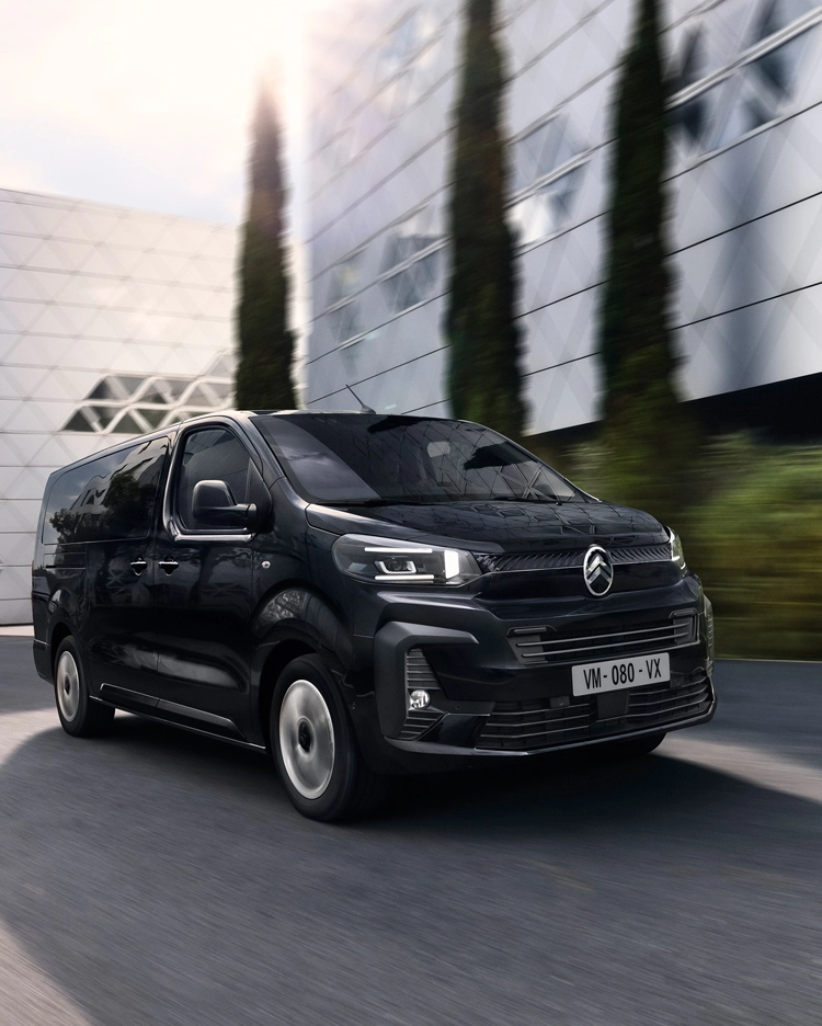 Dreiviertel-Frontansicht des Citroën ë-SpaceTourer während der Fahrt in einem Stadtgebiet, zeigt sein modernes elektrisches Design