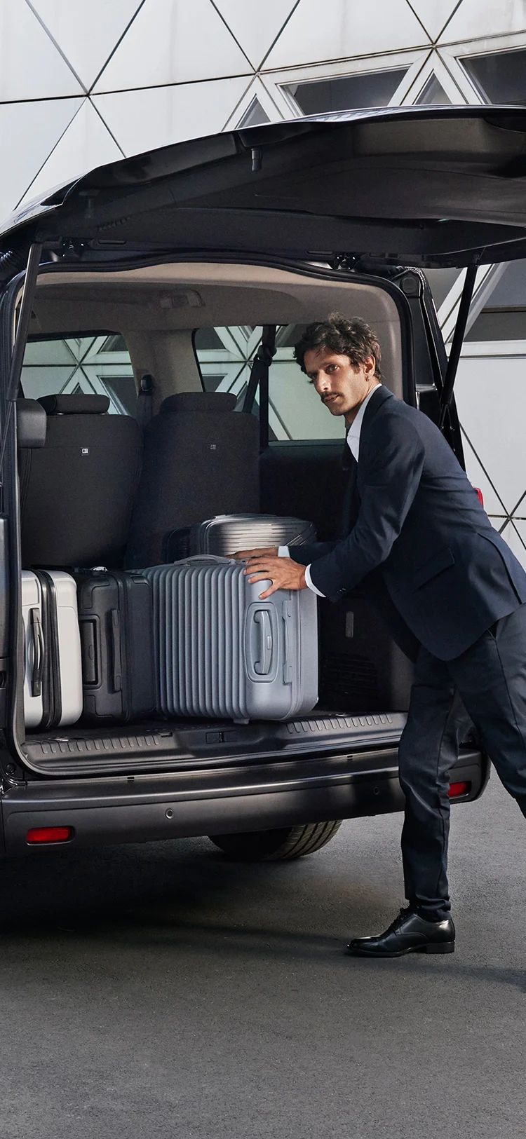 Heck des Citroën ë-SpaceTourer mit geöffnetem Kofferraum, zeigt mehrere Koffer beim Beladen